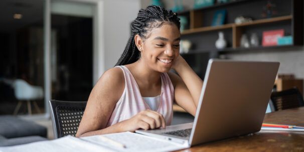 Une adolescente apprend en ligne à la maison sur son ordinateur portable