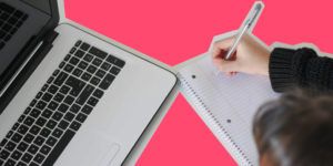 a photo of a woman taking notes in front of a computer