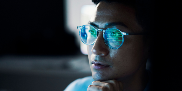 Man with reflection of code in his glasses
