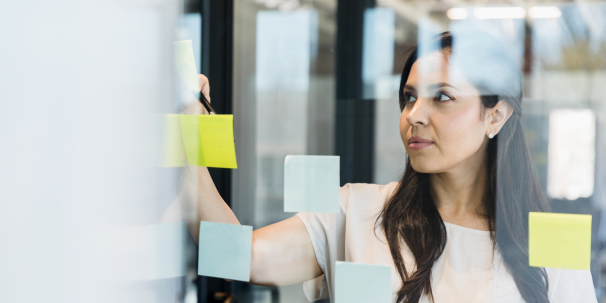 marketing manager brainstorming with sticky notes on board