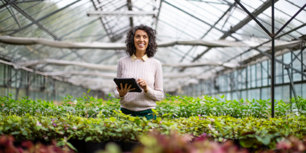 A sustainable business owner walks through her greenhouse