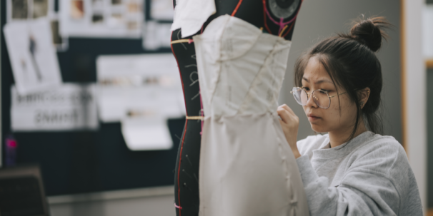Fashion student concentrates on dressmaking as part of a fashion course aimed at getting a job in the fashion industry