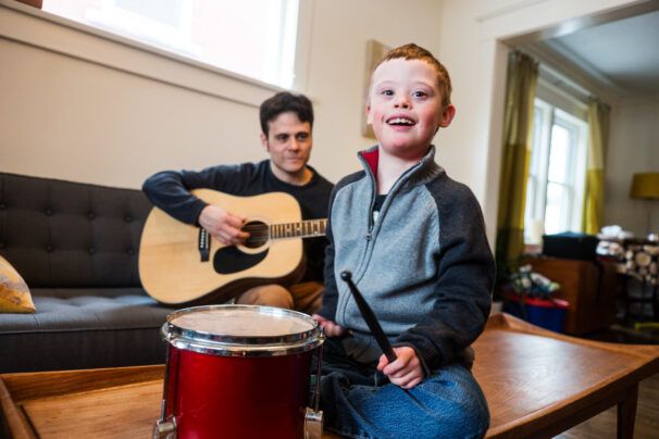 Music therapist conducts music therapy session with young boy with Down's syndrome