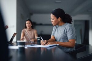 Two people discussing and working together in an office.
