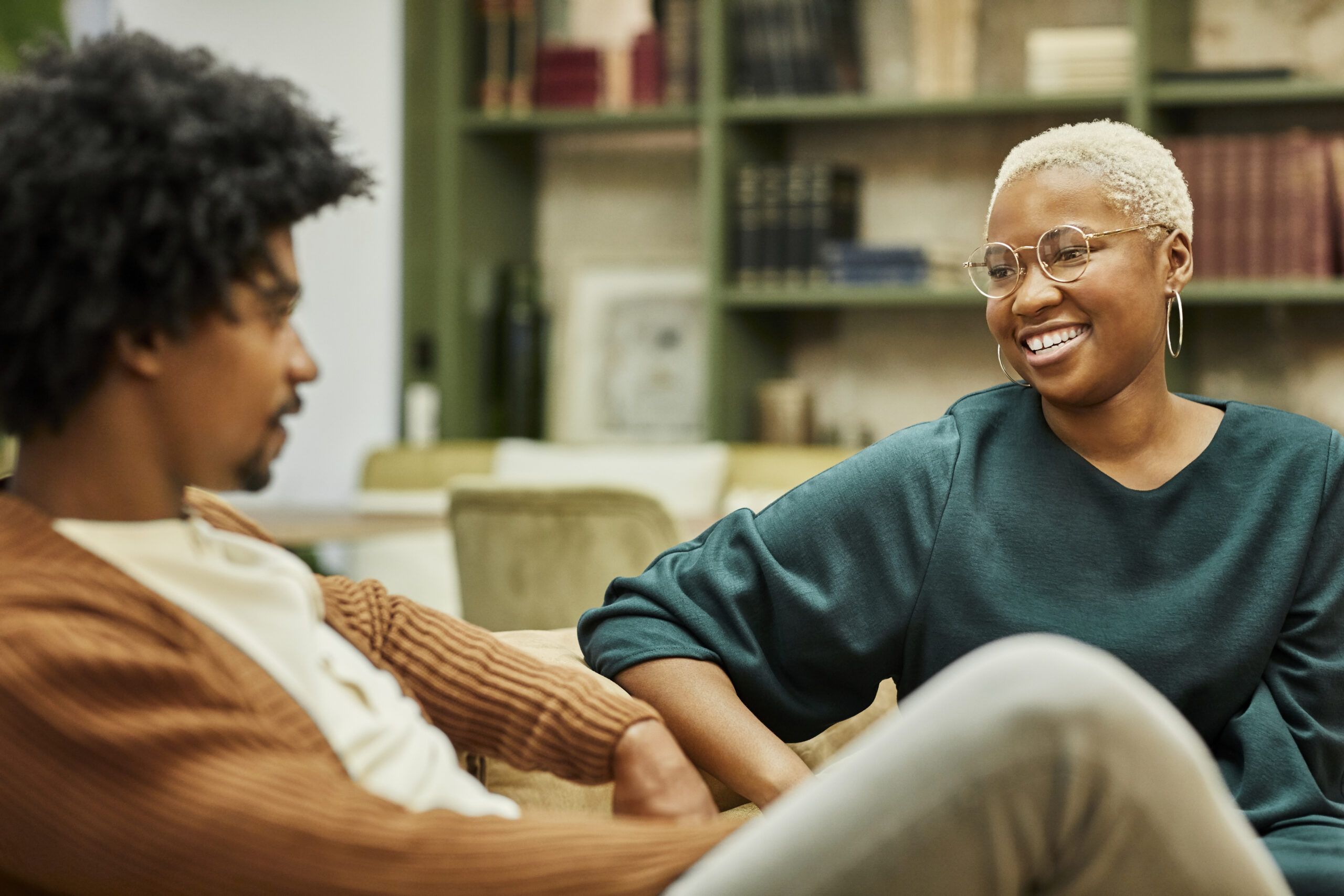 Two coworkers sitting on sofa in a creative office.